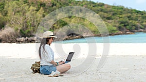 Lifestyle freelance woman using laptop working and relax on the beach.Â 